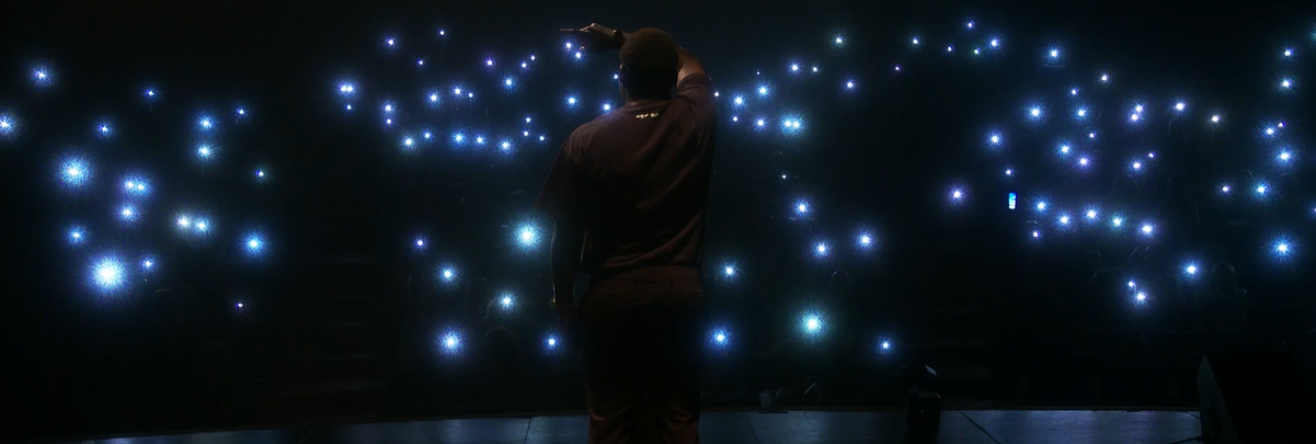 THE ALONE en spectacle, public avec lampes de téléphone